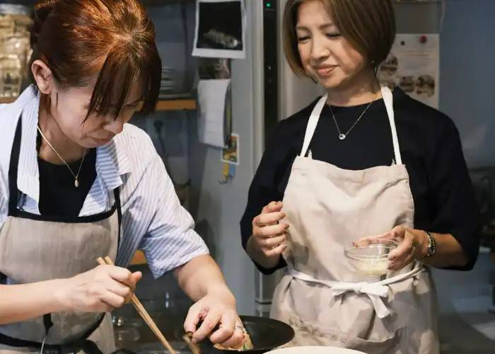A guest and a host cooking in a private cooking class in Tokyo.